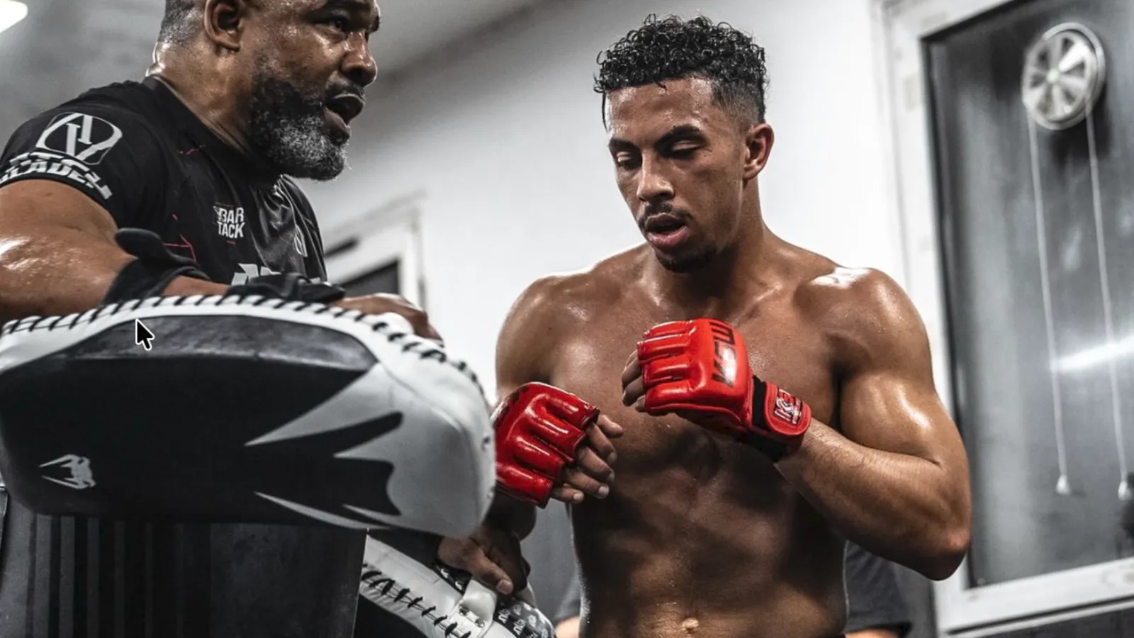Coach et combattant aux paos lors d’un entraînement de MMA